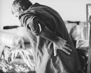 A man holds his back in pain