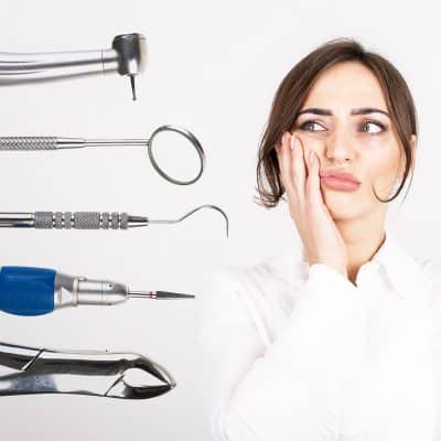 A woman holds the side of her face in tooth pain